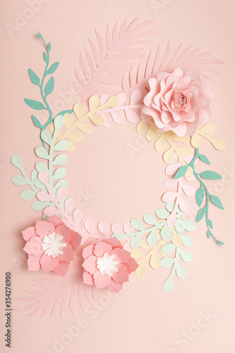 Flat lay of paper flowers on pastel pink background. Summer fashion and trend...