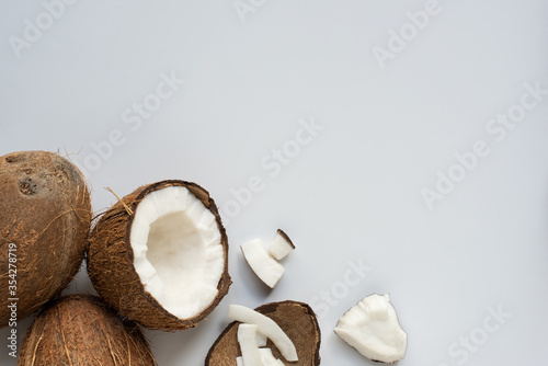 top view of fresh tasty cracked coconuts with flakes and shell on white background