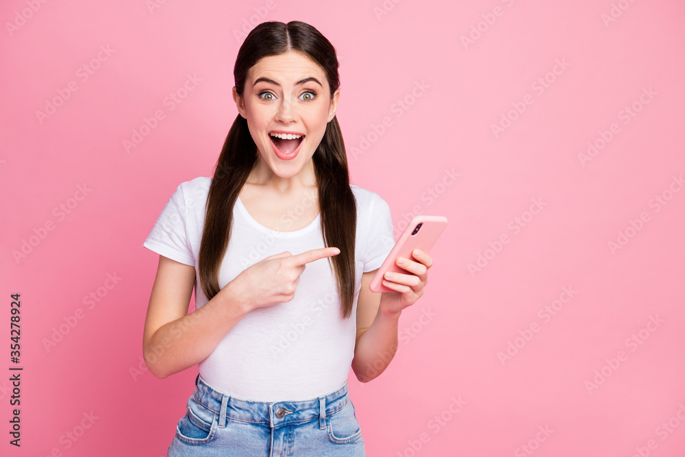 Portrait of her she nice attractive lovely pretty charming cheerful cheery glad amazed girl holding in hands using demonstrating digital device reaction isolated over pink pastel color background Portrait of her she nice attractive lovely pretty charming cheerful cheery glad amazed girl holding in hands using demonstrating digital device reaction isolated over pink pastel color background