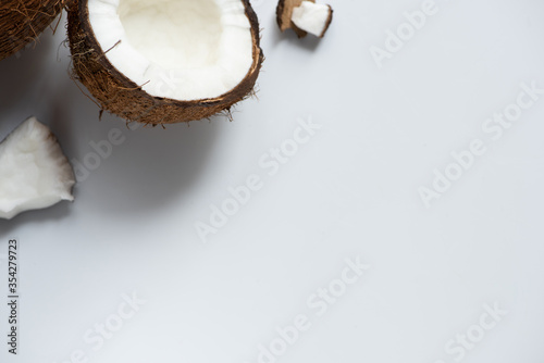top view of cracked tasty coconut half and pieces on white background