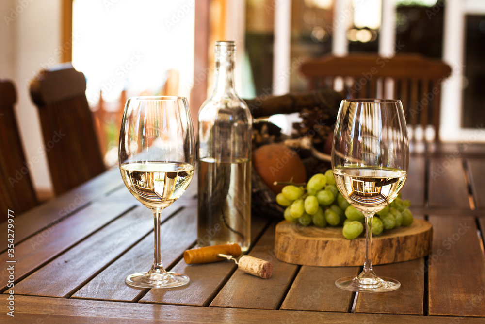 Dos copas de vino están sobre una mesa con una playa al fondo