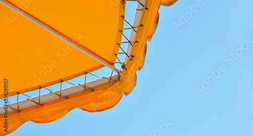 Fototapeta Naklejka Na Ścianę i Meble -  Yellow sun umbrella on a blue sky background