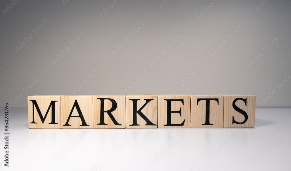 Markets text made with wooden blocks. It is illuminated by spotlight. Markets text made with wooden blocks. It is illuminated by spotlight.