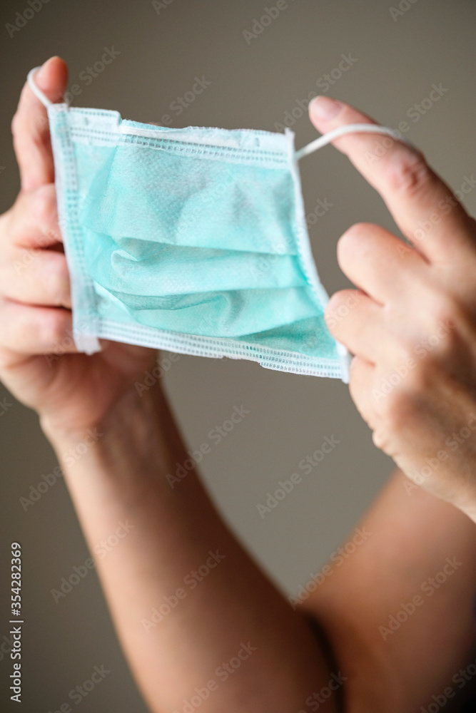 Woman putting on a protection mask to prevent from COVID-19 and other infections. Woman putting on a protection mask to prevent from COVID-19 and other infections.