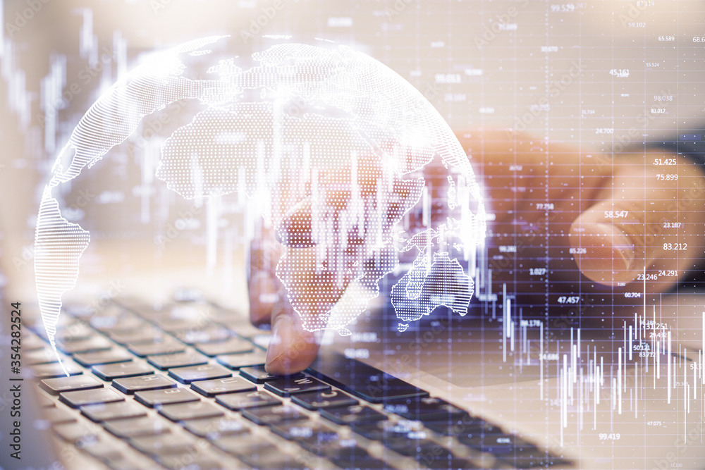 Hand typing on laptop and candlestick chart of falling stock Hand typing on laptop and candlestick chart of falling stock