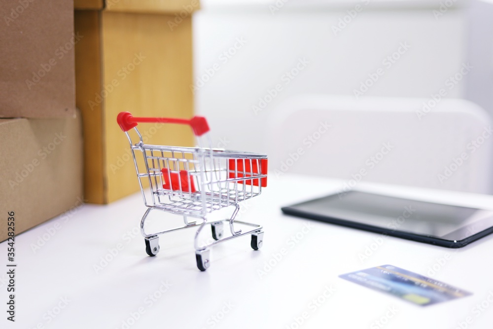 Small shopping cart for Internet online shopping e-commerce online delivery serviceconcept Small shopping cart for Internet online shopping e-commerce online delivery serviceconcept