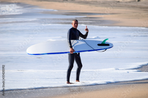 Japan surfing , sometimes during a typhoon, there are many waves in Japan especially in Hebara, Katsuura, Chiba. Westerner surfs large waves. Sunrise & at the beach with a surfer & his surf board. photo