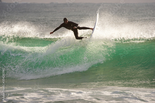 Japan surfing , sometimes during a typhoon, there are many waves in Japan especially in Hebara, Katsuura, Chiba. Westerner surfs large waves. Sunrise & at the beach with a surfer & his surf board. photo