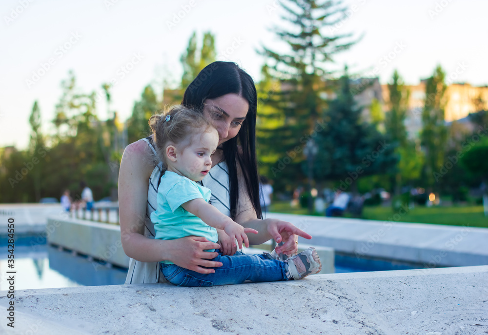 young woman with his little girl in the park