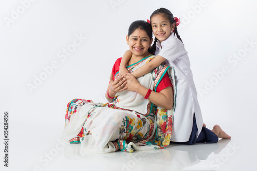 Little daughter embracing her mother at home. © G-images