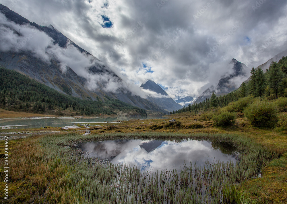 Akkem Lake at the foot of Belukha Mountain in Altai. Cloudy. Reflection in water.