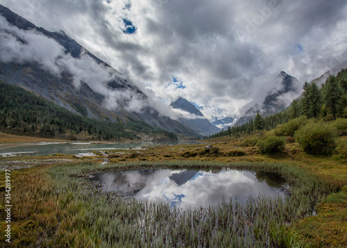 Akkem Lake at the foot of Belukha Mountain in Altai. Cloudy. Reflection in water.