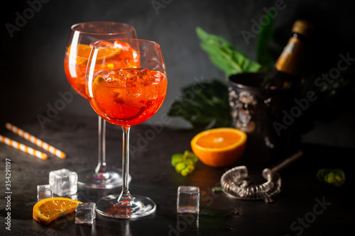 Aperol spritz cocktail in glass with fresh orange on dark background