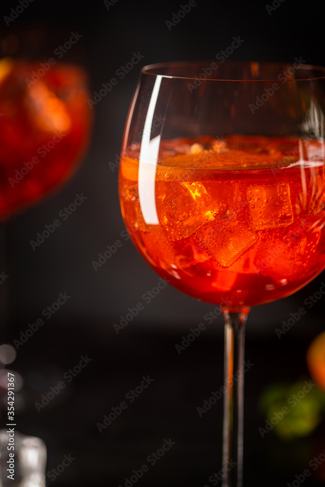 Aperol spritz cocktail in glass with fresh orange on dark background