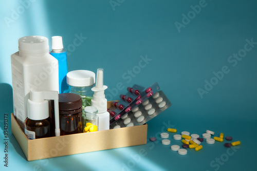 Jars of different medicines and A pile of colorful pills on the blue background at sun light. Background of drugs. Treatment concept. Medicine concept. 