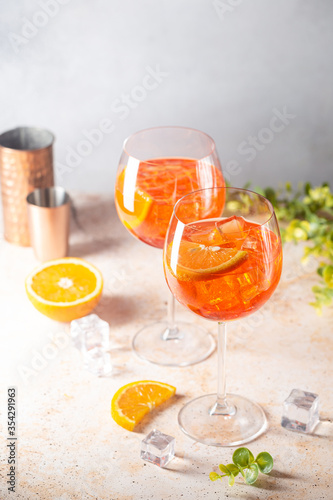 Aperol spritz cocktail in glass with fresh orange on light background
