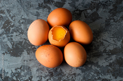 Chicken eggs on a dark gray background, visible orange yolk