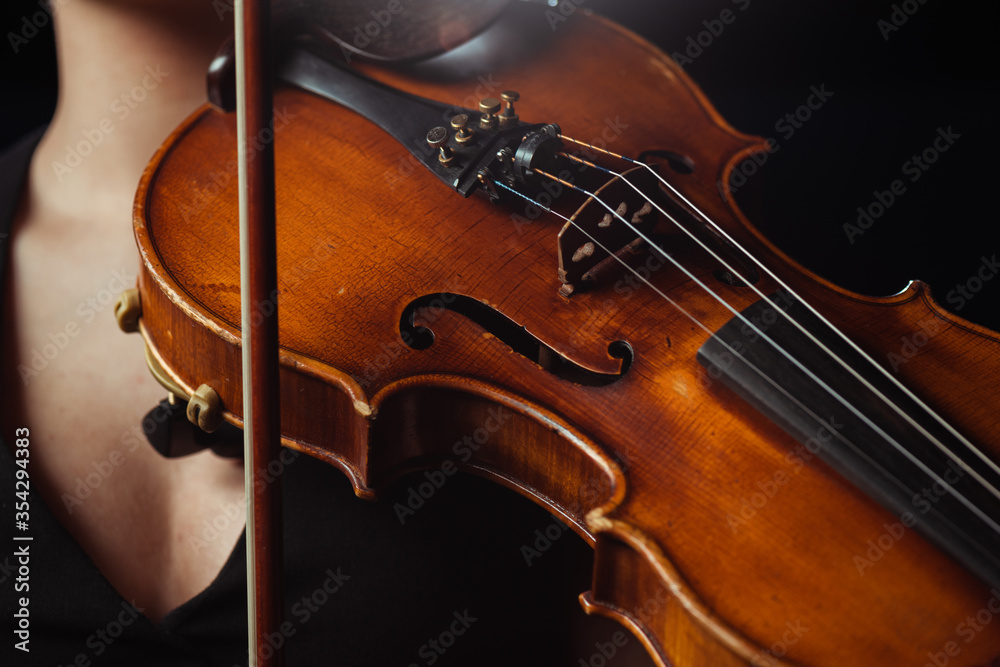 Fototapeta premium partial view of female musician playing symphony on violin isolated on black