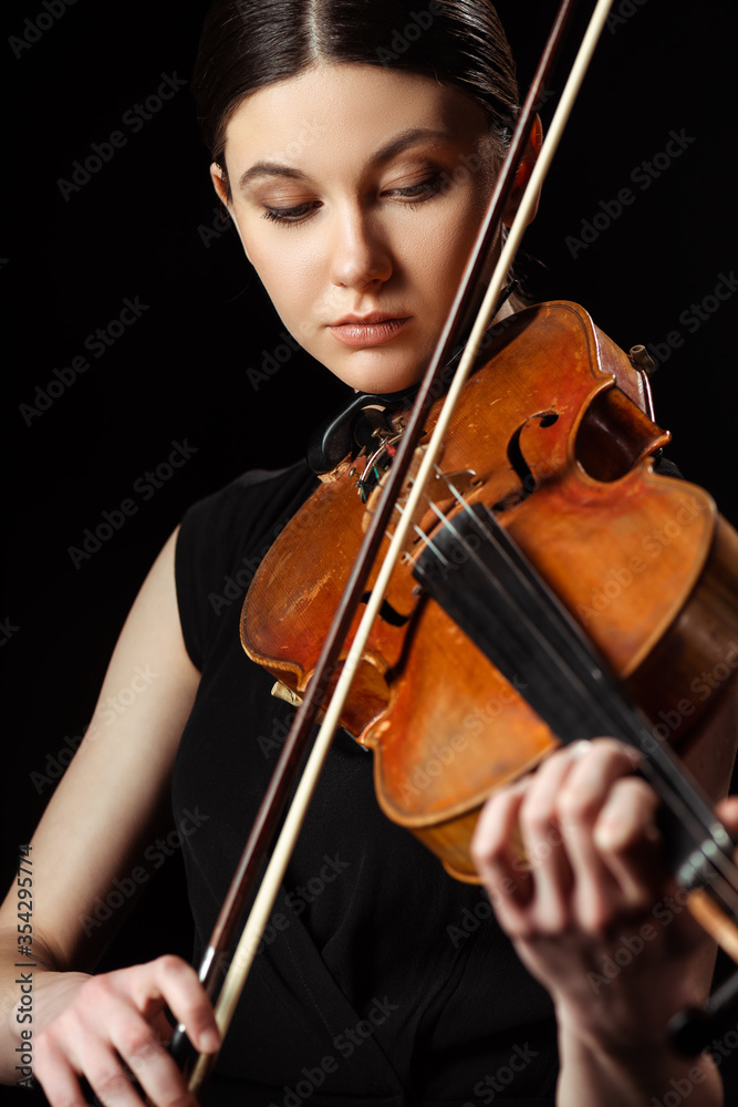 Fototapeta premium beautiful professional musician playing symphony on violin isolated on black