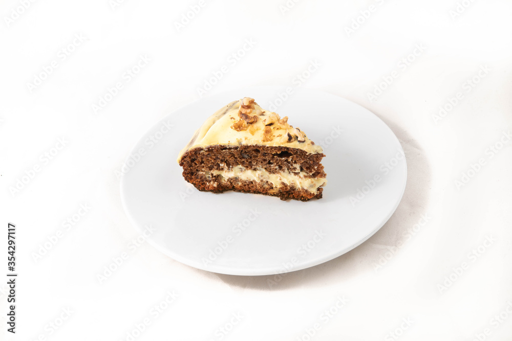 A slice of carrot cake being cut. On the white plate, isolated in white.