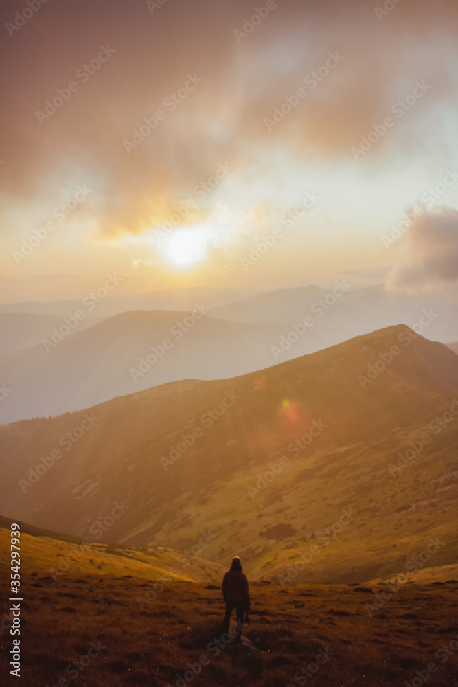 girl looking on the sunset in the mountains