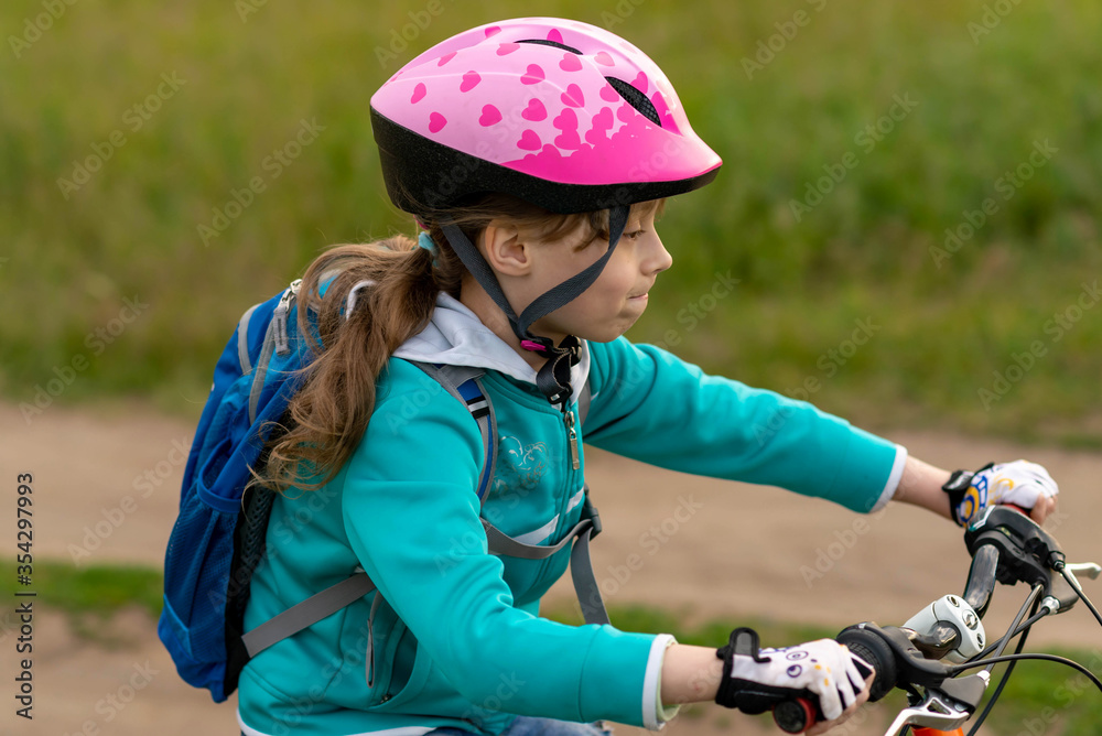 Portrait of a little girl on a bicycle and in a helmet. Portrait of a little girl on a bicycle and in a helmet.