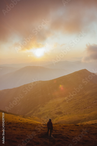 girl looking on the sunset in the mountains