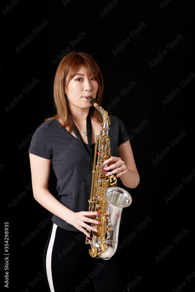 Naklejka premium サックスを演奏する若い日本人女性
