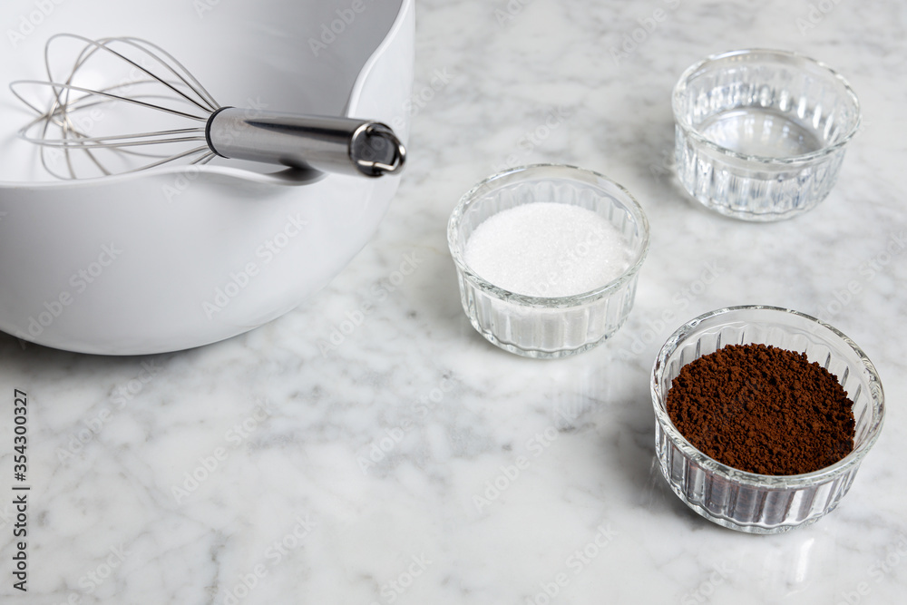 Dalgona coffee ingredients on a marble table: Instant coffee, sugar and water Dalgona coffee ingredients on a marble table: Instant coffee, sugar and water