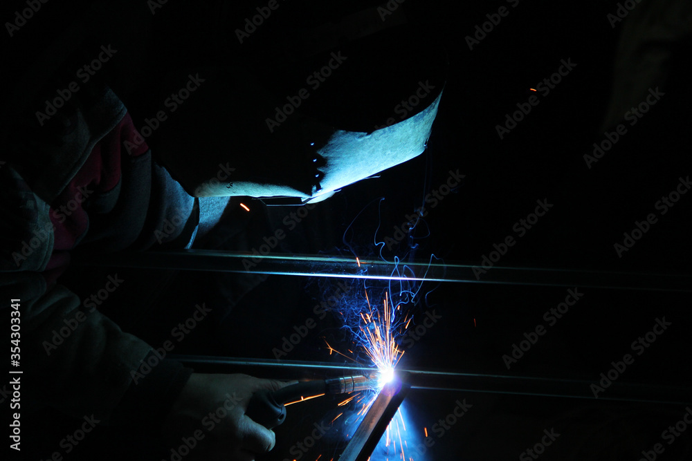 Sparks from welding. A man will weld metal. Workplace of the welder. Garage welder Sparks from welding. A man will weld metal. Workplace of the welder. Garage welder
