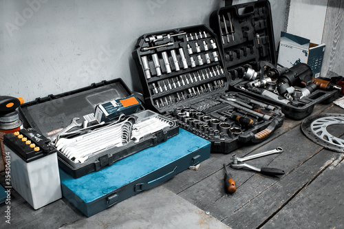 Service station, motorcycle repair, car repair, mechanical equipment, a set of tools in the workshop. Workbench with professional wrenches in drawers and spare parts.