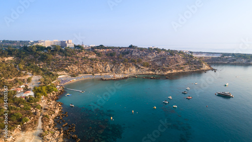 Aerial bird's eye view of Konnos beach, Cavo Greco Protaras, Paralimni, Famagusta, Cyprus. Famous tourist attraction golden sandy bay with boats, yachts in the sea, sunbeds, water sports, from above. © f8grapher