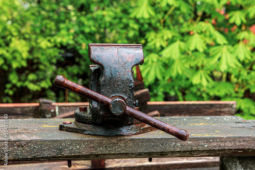 Old vise grips on a wooden bench in the backyard
