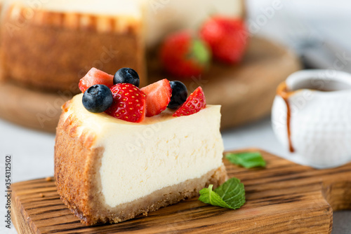 Fototapeta Naklejka Na Ścianę i Meble -  Cheesecake slice with summer berries on top. Slice of new york cheesecake served with berries
