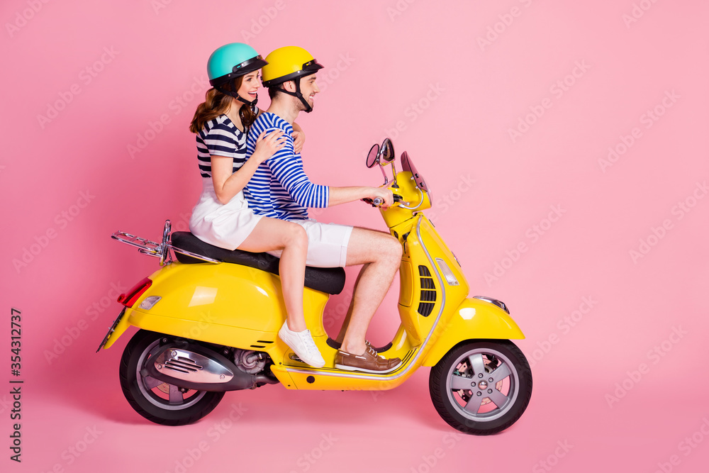 Profile side view portrait of his he her she nice attractive cheerful cheery couple riding moped having fun spending time traveling abroad isolated on pink pastel color background