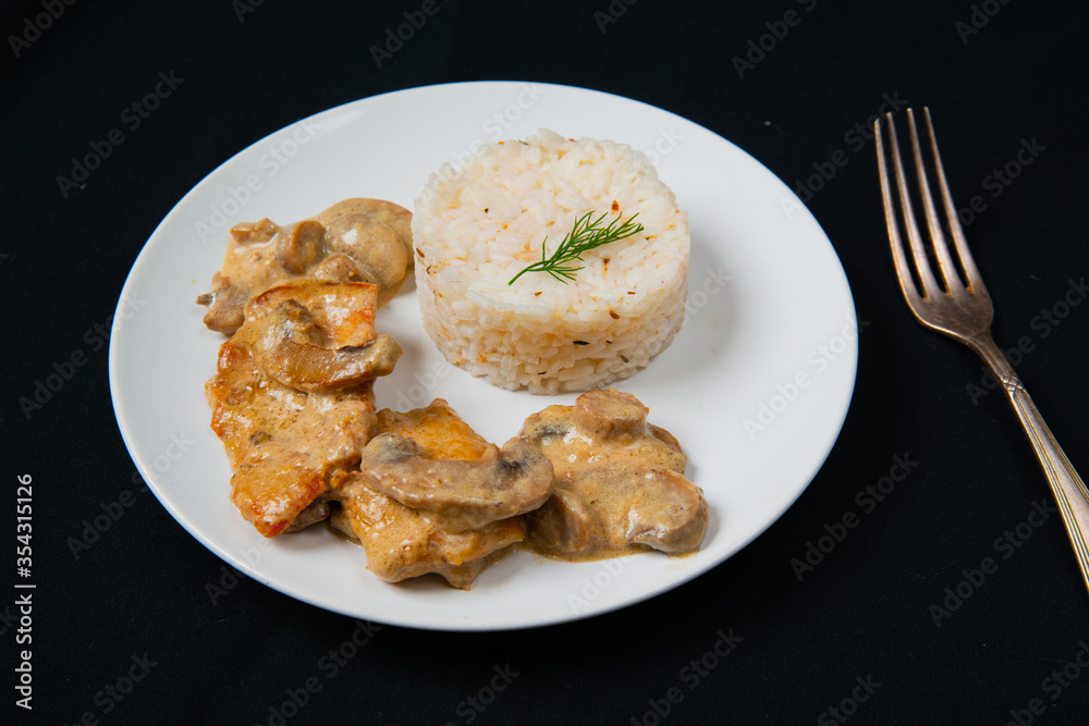 Chicken Breast in Creamy White Wine and Mushroom Sauce. With a silver fork in right. Chicken Breast in Creamy White Wine and Mushroom Sauce. With a silver fork in right.
