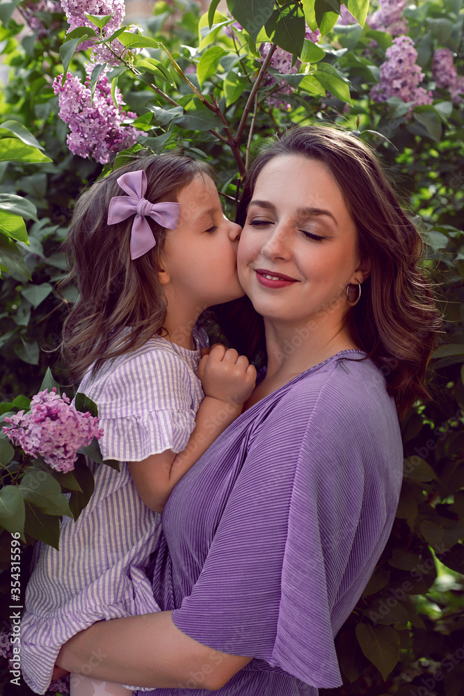 girl with mom in lilac dresses stand