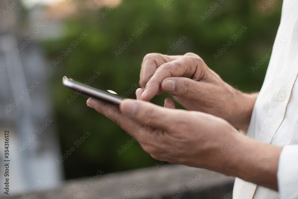 Man operating cellphone holding with his hand.