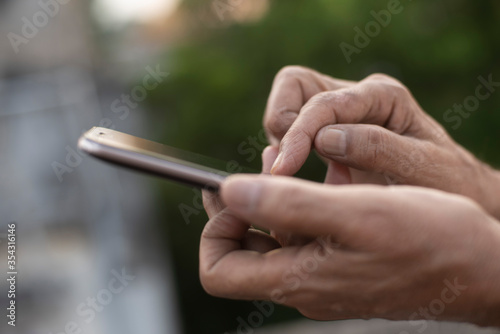 Man operating cellphone holding with his hand.
