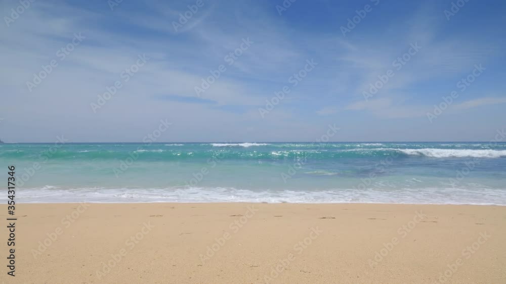 Panorama of a tropical beach with yellow sand and deep blue waves during warm sunny day on island in indian ocean