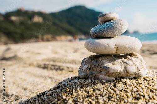 Stones pyramid on pebble beach symbolizing stability  zen  harmony  balance with mountain and sky in background.