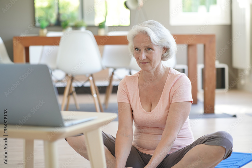 Senior woman doing fitness exercises from home- virtual classes Senior woman doing fitness exercises from home- virtual classes