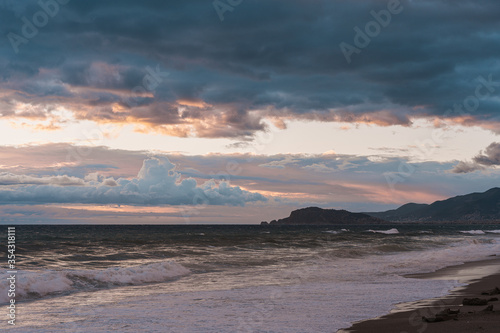 Beach at sunset with beautiful reflections  clouds and mountains on horison