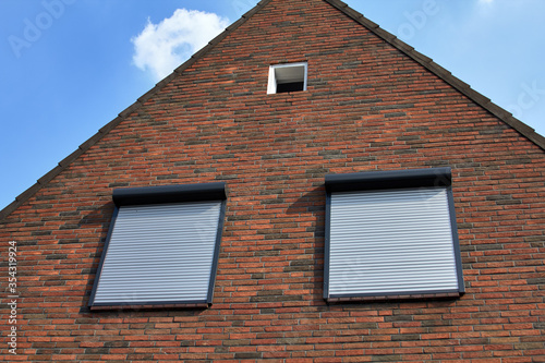 Windows with rolling shutters on the brick wall. Houce protection.
