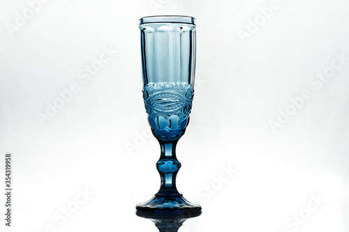 Full blue wineglass on white background. Isolated. Backlight.