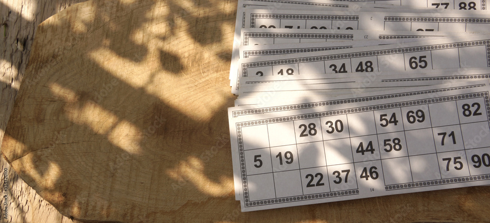 Board game lotto cards lie on wooden surface outdoors there is space for text Board game lotto cards lie on wooden surface outdoors there is space for text