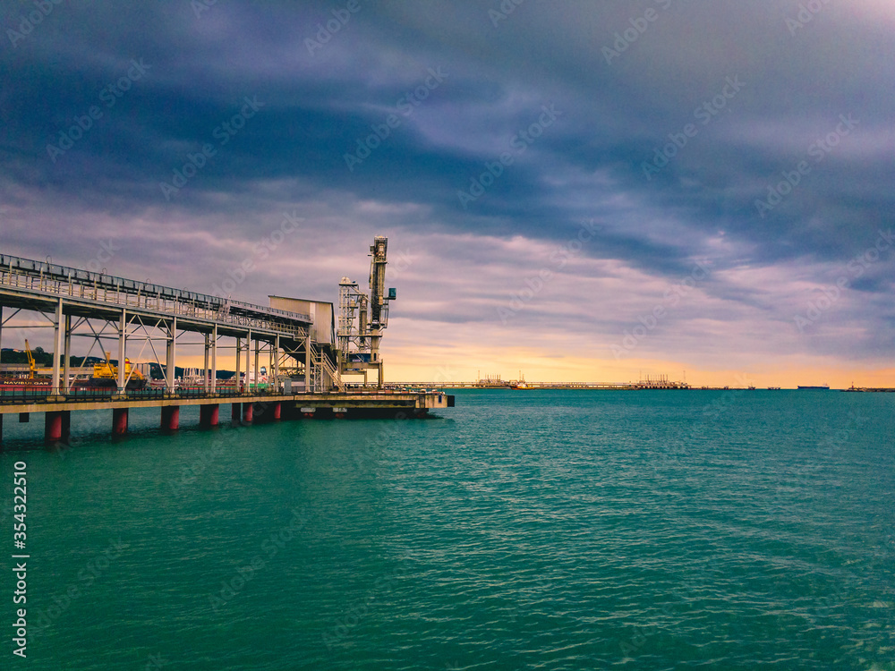 Grain pier in the seaport with greenish sea water and cloudy sky. Grain pier in the seaport with greenish sea water and cloudy sky.