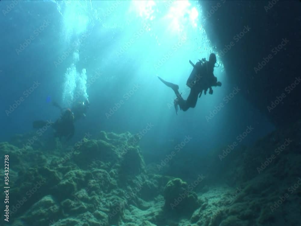 scuba divers exploring scenery underwater sun beams and rays sun shine silhouette ocean scenery scuba divers exploring scenery underwater sun beams and rays sun shine silhouette ocean scenery