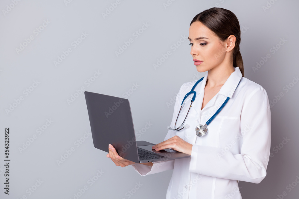 Photo of beautiful professional doc lady watch modern technology notebook novelty innovation medical reform covid disease wear stethoscope white lab coat isolated grey color background