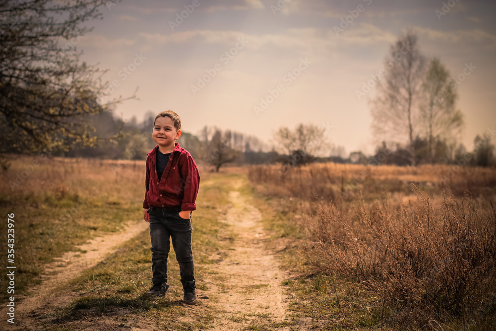 Baby boy walking the field path and smile.